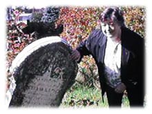 Patsy looking at tombstone which is about ready to fall over in Old St. Luke's Scottish Cemetery in Bathurst, New Brunswick, Canada